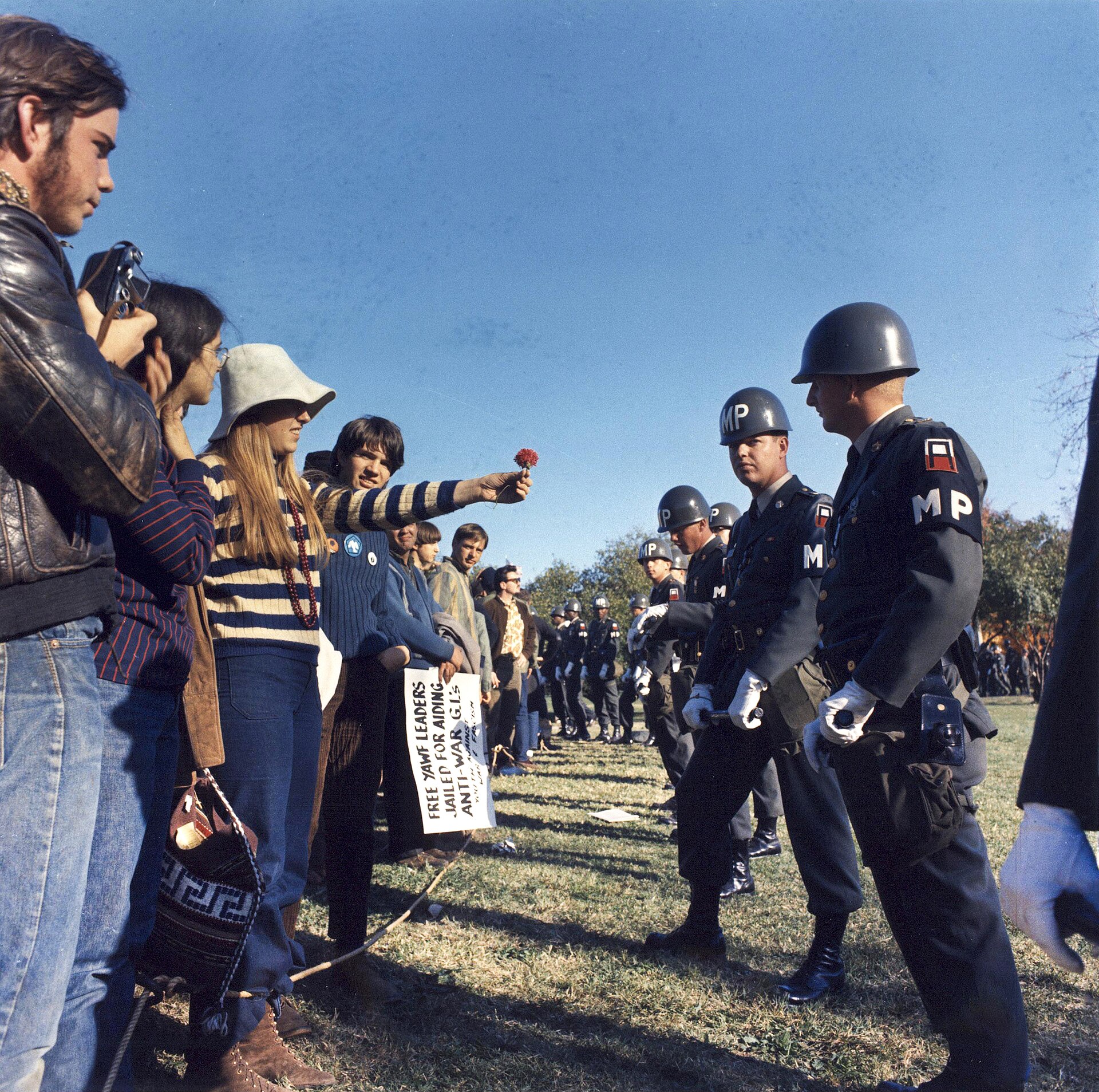 A female demonstrator offers a flower to military police on guard at the Pentagon during an anti-Vietnam demonstration. Arlington, Virginia, USA