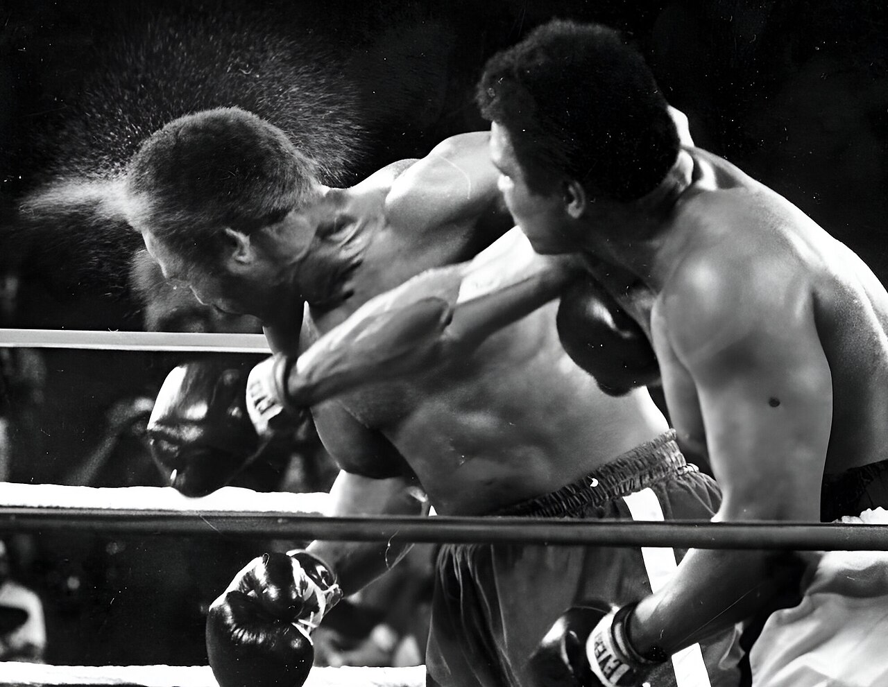 Muhammad Ali's right knocks perspiration from head of George Foreman in the 7th round